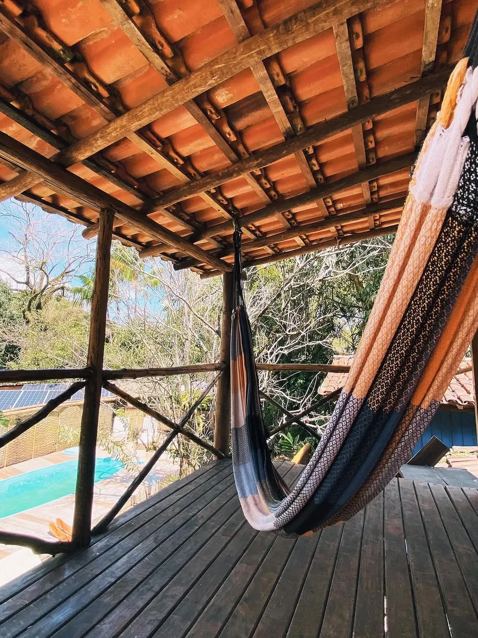 Varanda da suíte Tainha com rede e vista para a piscina