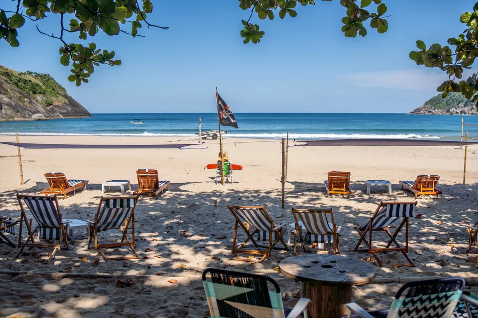 Cadeiras e bandeira na areia da Praia do Bonete