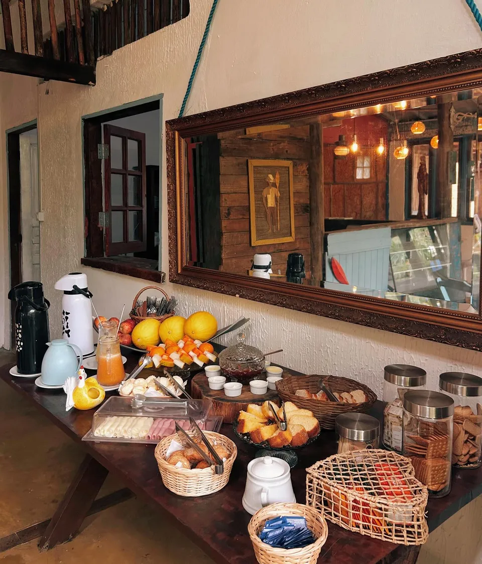 Café da manhã servido no salão, com frutas, pães e bolos