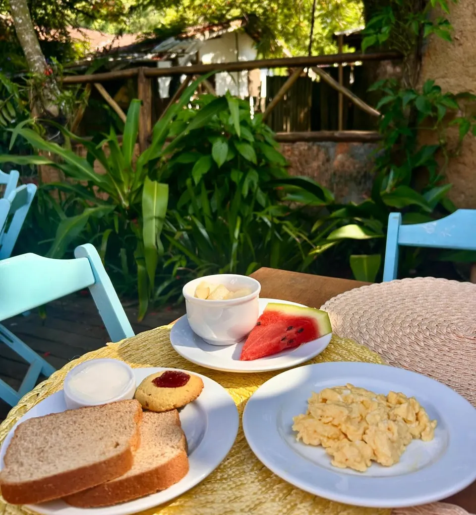 Café da manhã com frutas, pão e ovos mexidos no jardim