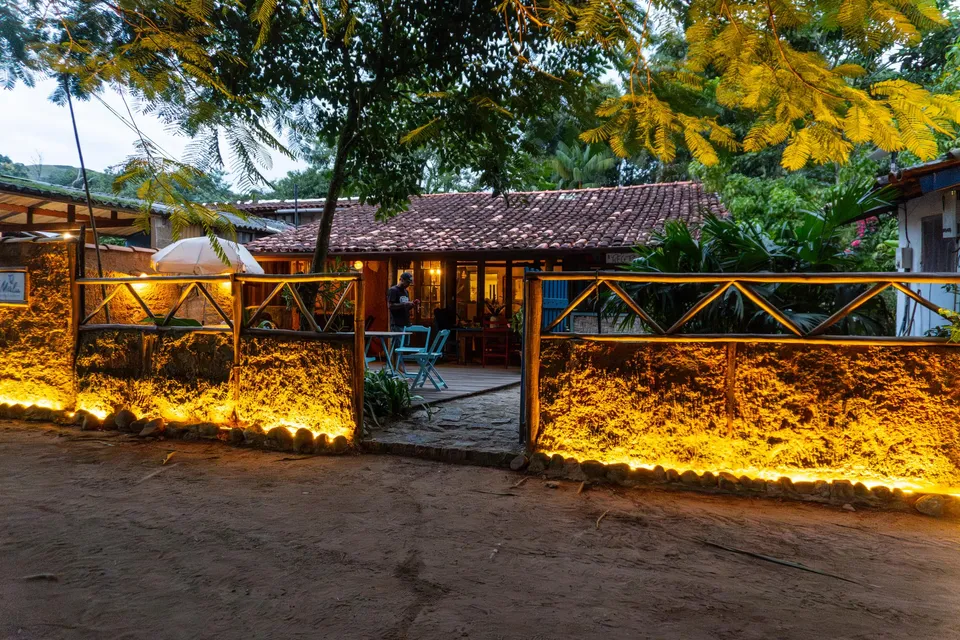 Fachada da pousada iluminada ao entardecer