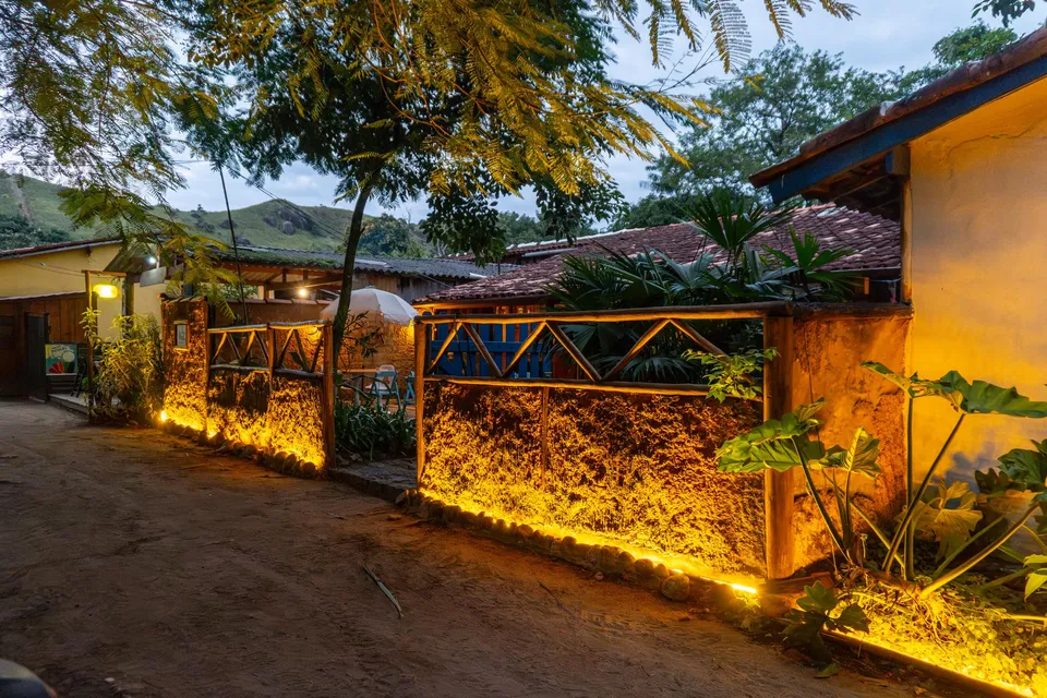 Muro de pedra iluminado na entrada da pousada