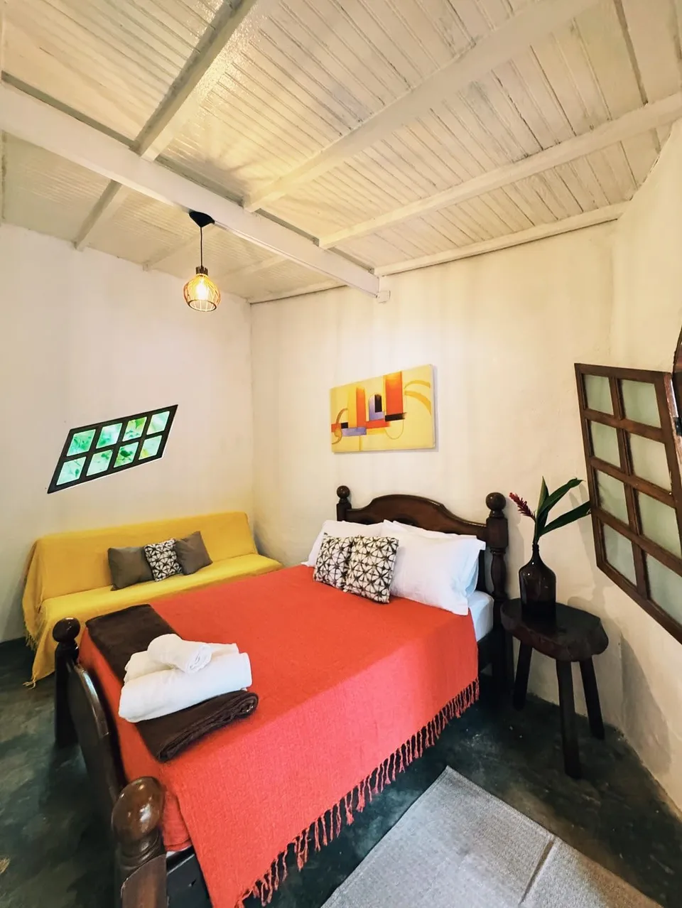 Suíte Carapau com cama de casal e colcha vermelha