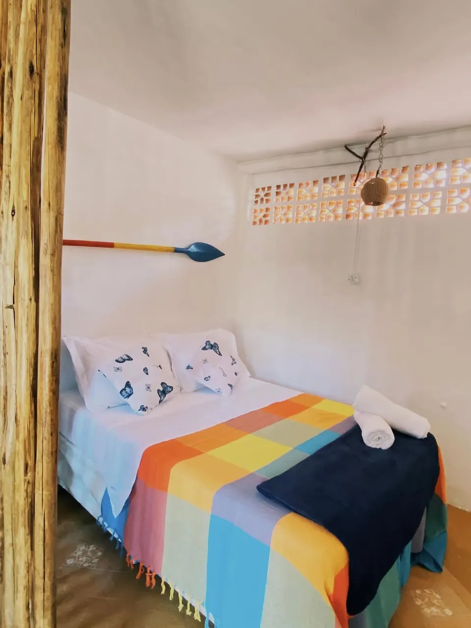 Cama de casal com colcha listrada no Chalé Bonito