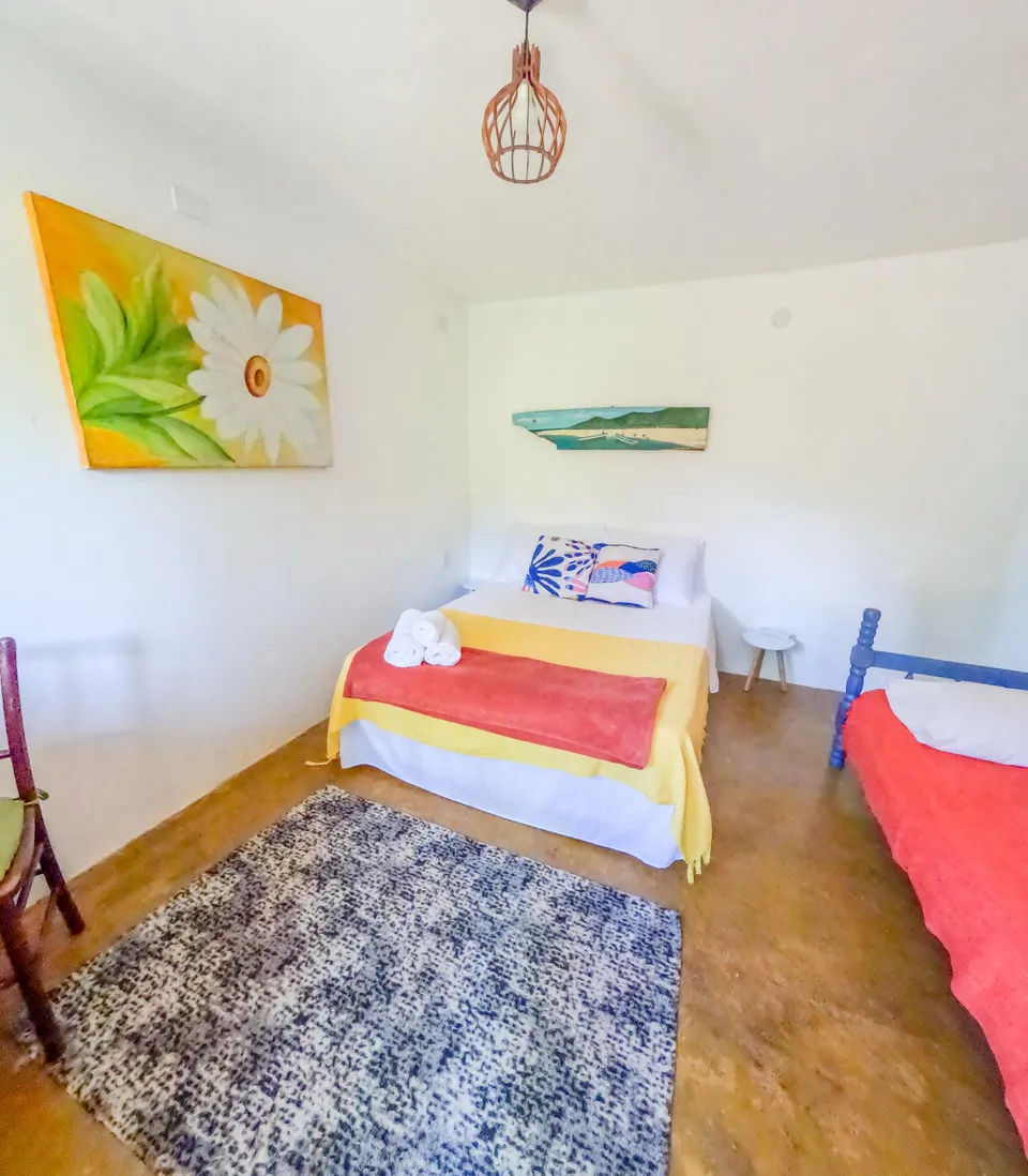 Suíte Manjuba com quadro de flor e duas camas
