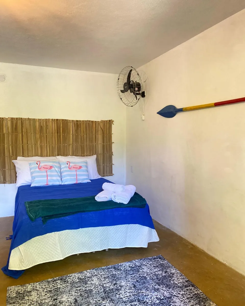 Cama de casal da suíte Sororoca com cabeceira de bambu